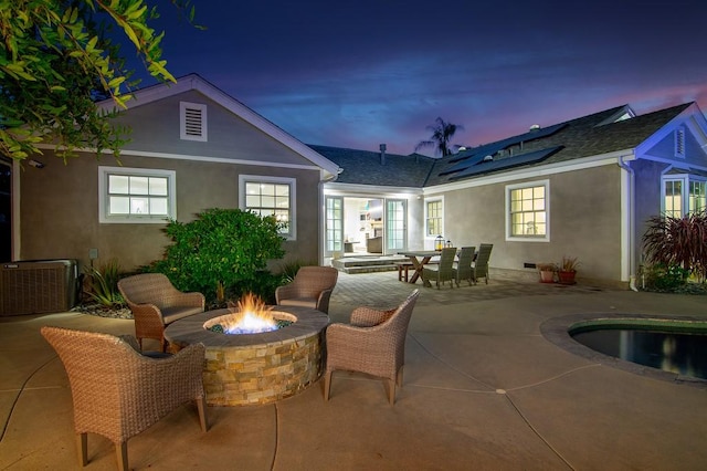 view of patio with outdoor dining area, central AC unit, and an outdoor fire pit