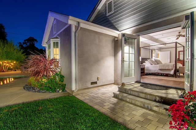 property exterior at twilight with ceiling fan and a patio area