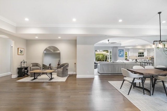 dining area with recessed lighting, arched walkways, and wood finished floors