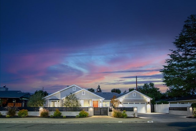 view of front of home featuring a fenced front yard, an attached garage, driveway, and a gate