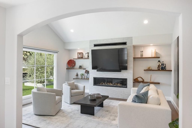 living room featuring recessed lighting, a fireplace, and lofted ceiling