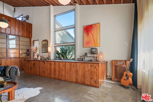 interior space with concrete flooring, wood ceiling, high vaulted ceiling, and a wealth of natural light