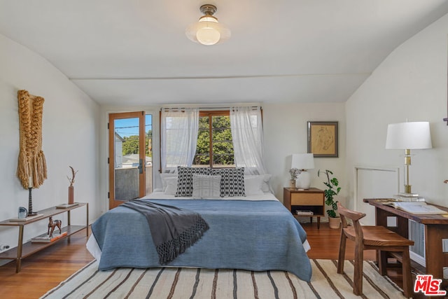 bedroom featuring wood-type flooring, lofted ceiling, and access to outside