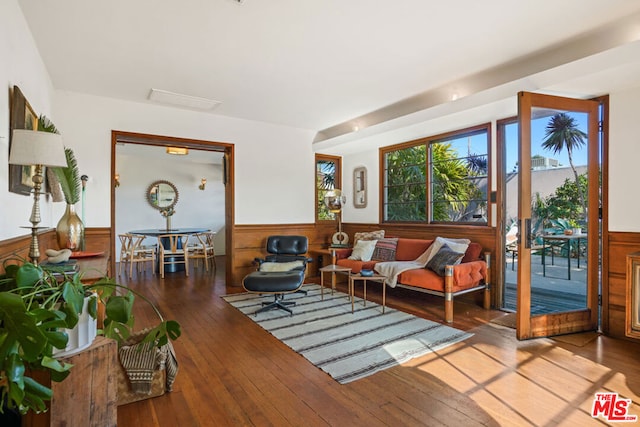 sitting room with wood walls and hardwood / wood-style floors