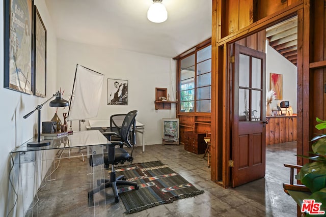 office area with concrete flooring and vaulted ceiling