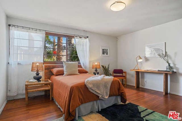 bedroom with dark hardwood / wood-style flooring