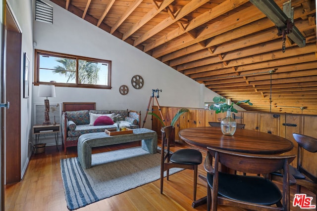 dining area with wooden ceiling, vaulted ceiling with beams, and hardwood / wood-style floors