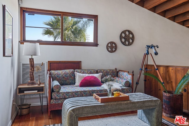 bedroom featuring beamed ceiling, hardwood / wood-style floors, and multiple windows