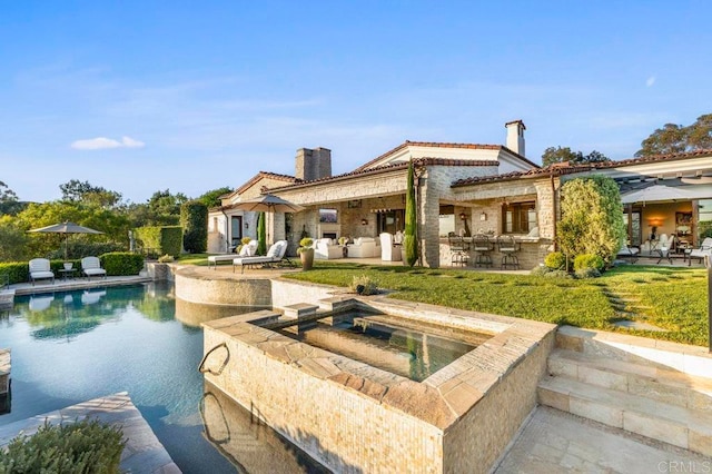 back of house with a patio and a pool with hot tub