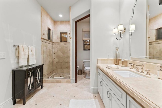 bathroom featuring tile patterned floors, a shower with door, vanity, and toilet