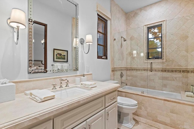 full bathroom featuring tiled shower / bath, vanity, toilet, and tile patterned floors