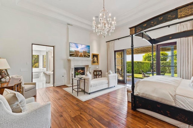 bedroom with multiple windows, access to exterior, hardwood / wood-style floors, and ensuite bathroom