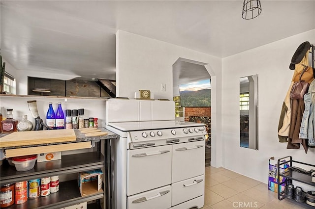 kitchen with double oven range, white cabinetry, and light tile patterned flooring