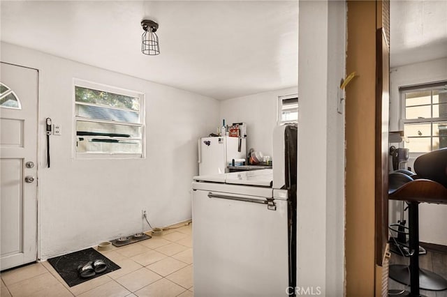 foyer entrance with light tile patterned floors and water heater