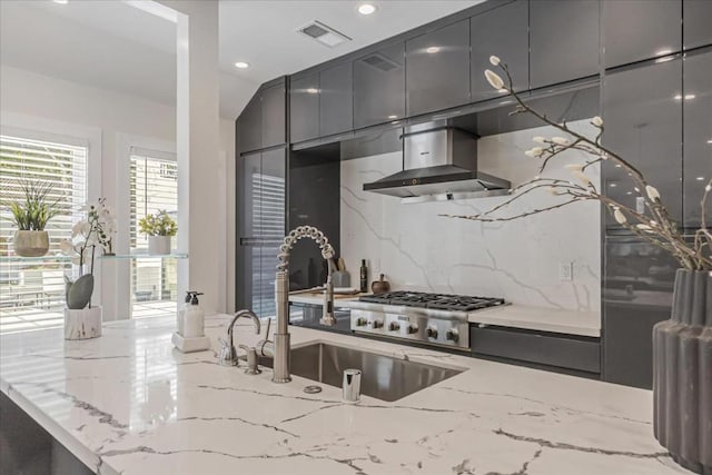 kitchen featuring tasteful backsplash, sink, extractor fan, and light stone counters