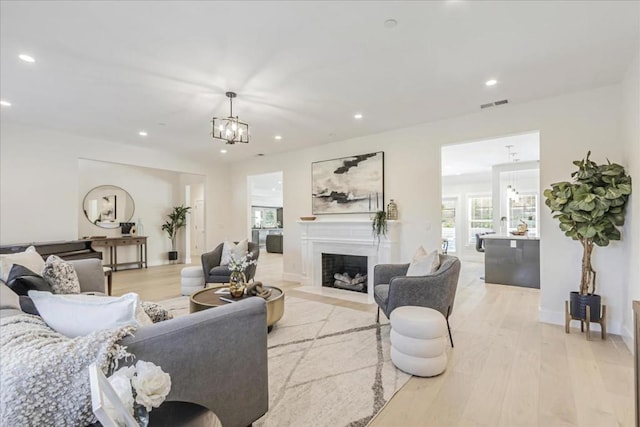 living room with an inviting chandelier and light hardwood / wood-style flooring