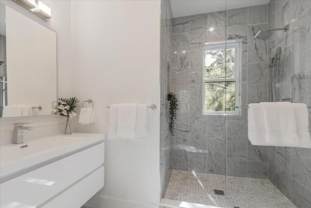 bathroom with tiled shower and vanity