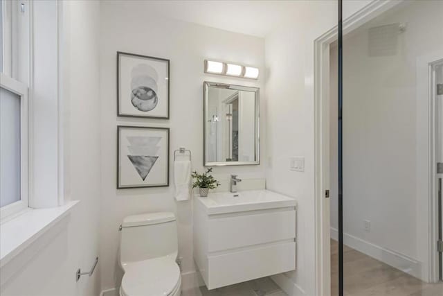 bathroom with toilet, vanity, and hardwood / wood-style flooring