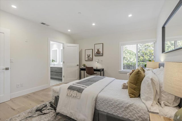 bedroom with light hardwood / wood-style flooring and ensuite bath