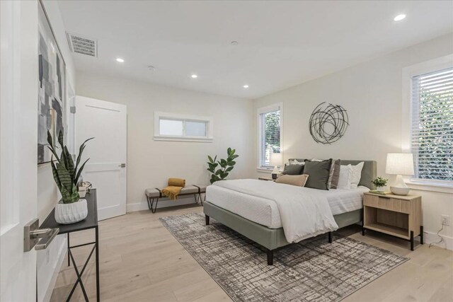 bedroom featuring light hardwood / wood-style floors and multiple windows