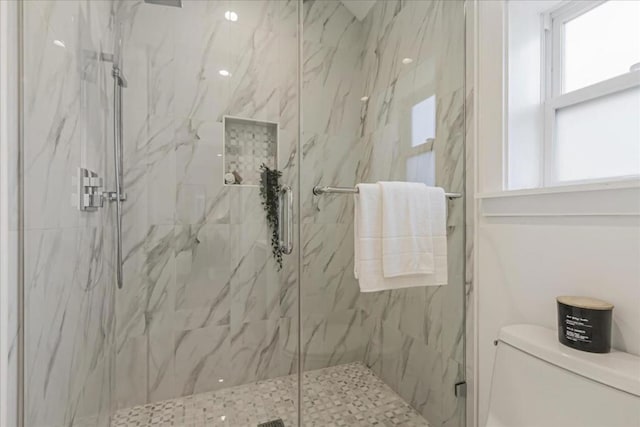 bathroom featuring toilet and an enclosed shower