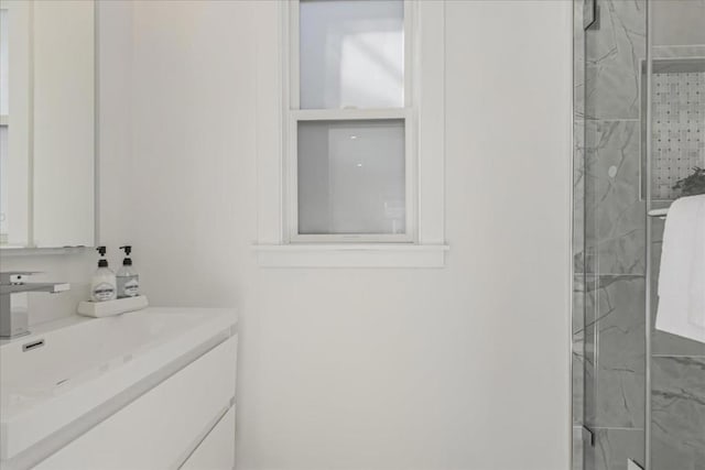 bathroom with a shower with door and vanity