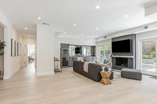 living room featuring beverage cooler and light hardwood / wood-style flooring