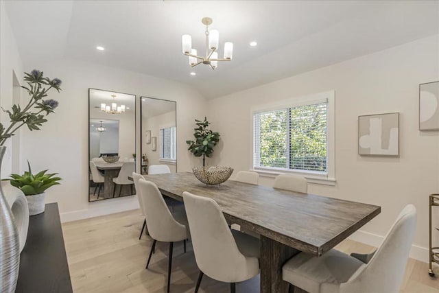 dining room with light wood-type flooring, a chandelier, and lofted ceiling