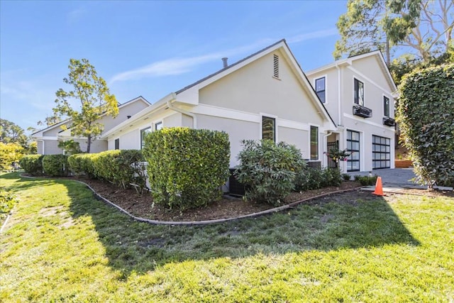 view of home's exterior with a garage and a lawn