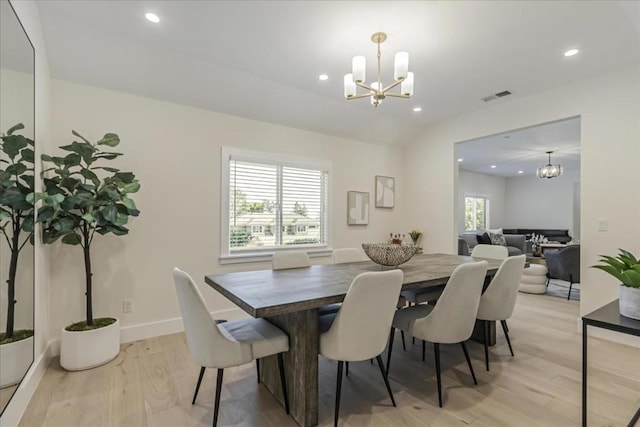 dining area with a notable chandelier and light hardwood / wood-style flooring