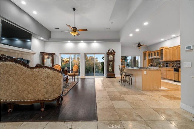 interior space with recessed lighting, a towering ceiling, baseboards, and ceiling fan