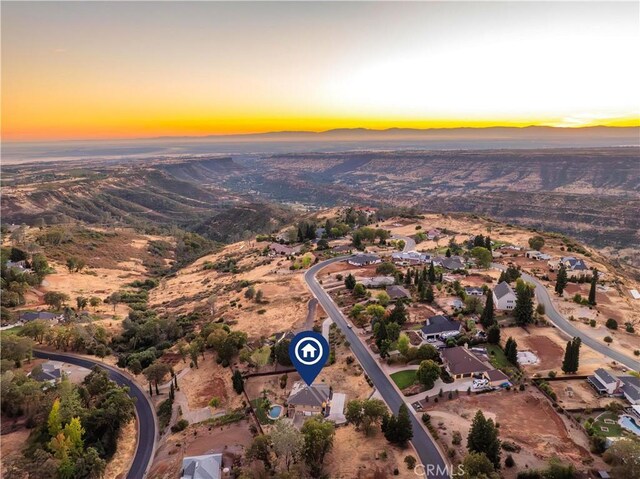 aerial view at dusk featuring a residential view and a mountain view