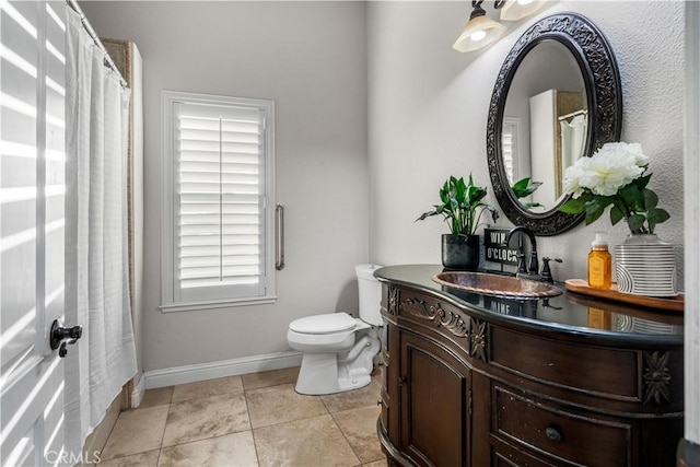 bathroom with baseboards, tile patterned flooring, vanity, and toilet