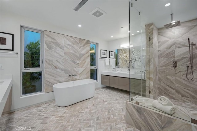 bathroom with vanity, tile walls, and independent shower and bath