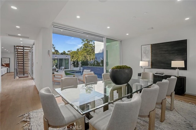 dining area featuring expansive windows and light hardwood / wood-style floors