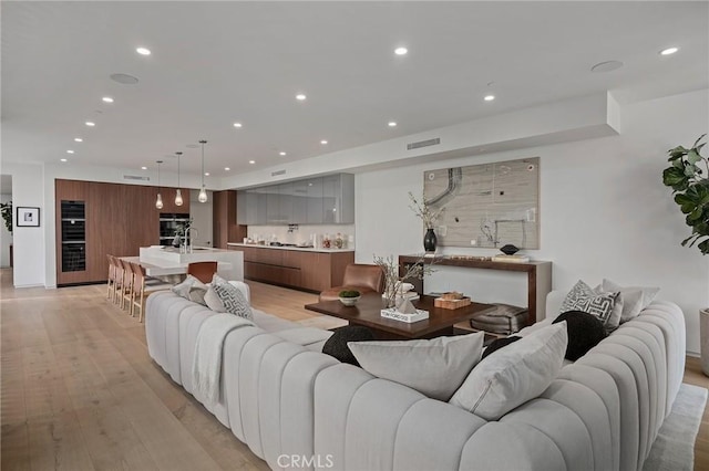 living room with sink and light hardwood / wood-style flooring