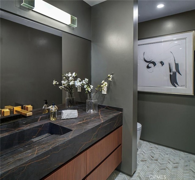 bathroom with tile patterned flooring, vanity, and toilet