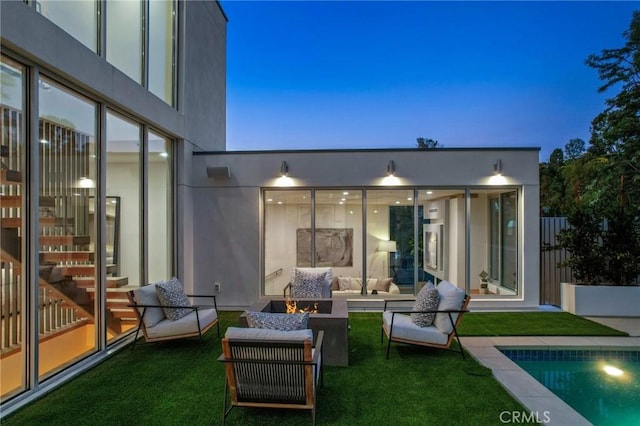 rear view of property with a patio area, a yard, and an outdoor fire pit