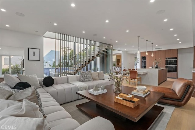 living room with light wood-type flooring and sink