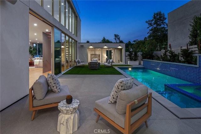 pool at dusk featuring a patio area