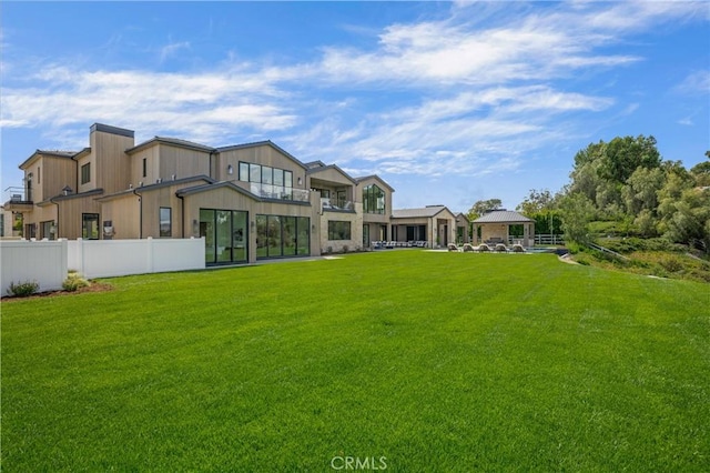 rear view of house featuring a lawn and a gazebo