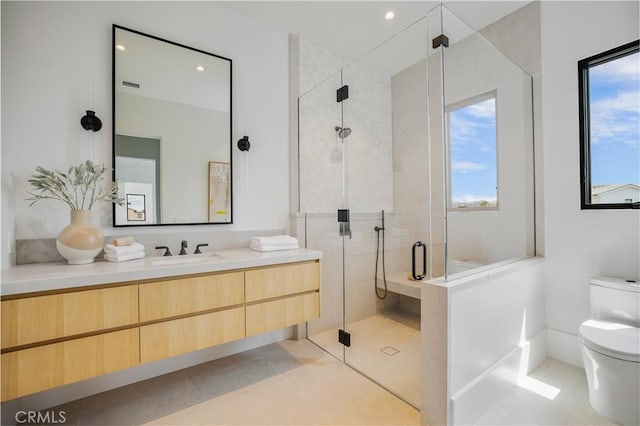 bathroom featuring tile patterned flooring, vanity, toilet, and a wealth of natural light