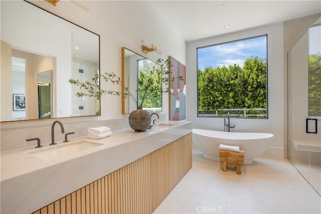 bathroom featuring tile patterned floors, vanity, and a tub