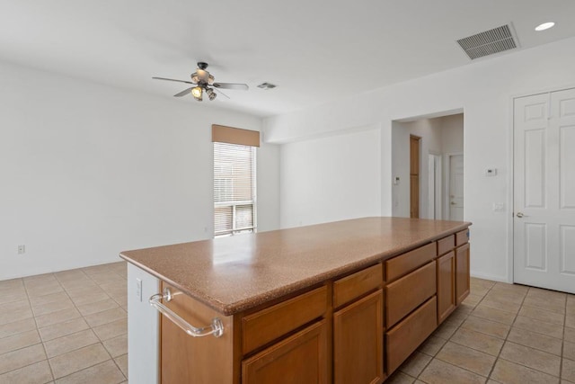 kitchen featuring light tile patterned floors, a kitchen island, and ceiling fan