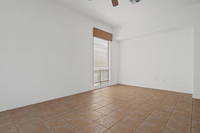 tiled spare room with ceiling fan