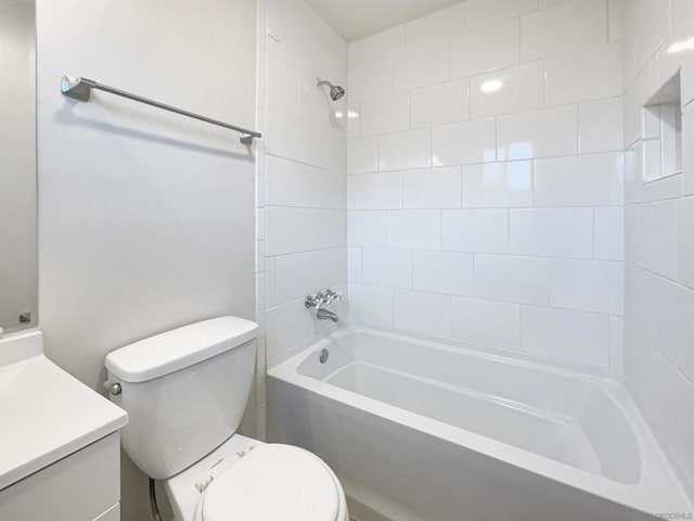 full bathroom with vanity, tiled shower / bath combo, and toilet