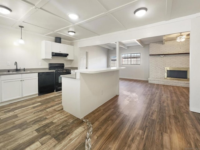 kitchen featuring sink, white cabinetry, hanging light fixtures, and black appliances