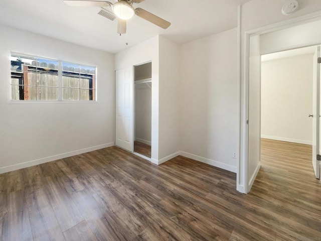 unfurnished bedroom with a closet, ceiling fan, and dark hardwood / wood-style flooring