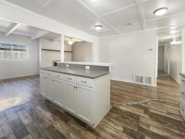 kitchen with white cabinetry, a center island, ceiling fan, and dark wood-type flooring