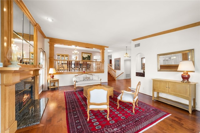 dining room featuring crown molding, a fireplace, dark hardwood / wood-style floors, and ornate columns